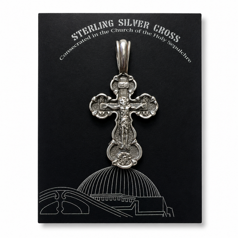 Sterling silver crucifix pendant displayed on a black card with “Sterling Silver Cross” text, Church of the Holy Sepulchre reference, INRI detail, and white architectural line art.