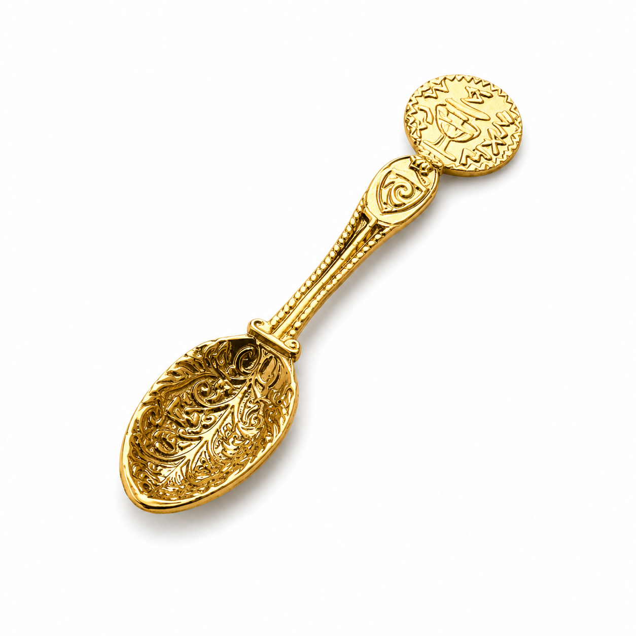 Gold decorative spoon with intricate designs on a white background