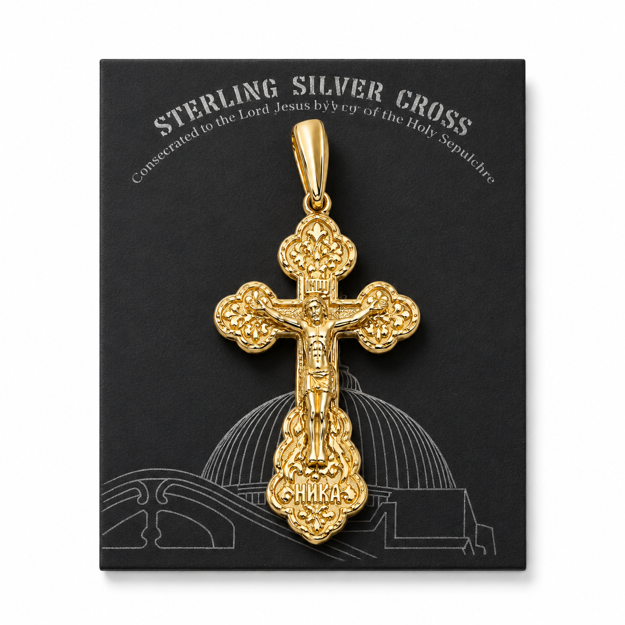 A gold-plated sterling silver Orthodox crucifix pendant placed on its black gift box, which features a silver line drawing of the Church of the Holy Sepulchre dome and inscription.