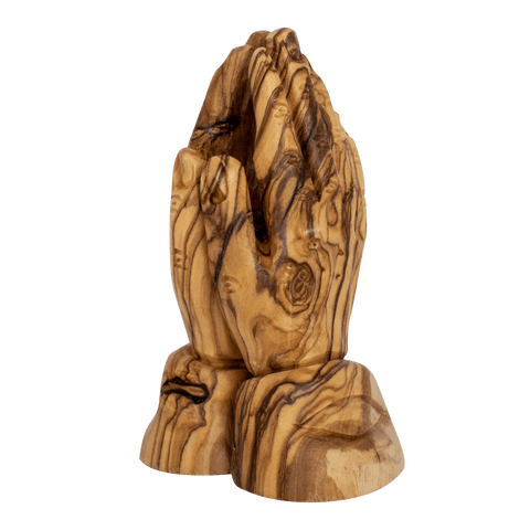 Close-up of carved fingers on olive wood praying hands figurine