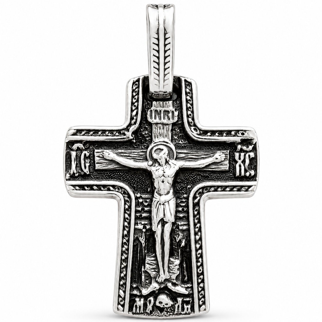 Front-view silver-tone Orthodox crucifix pendant with raised Jesus figure, dark oxidized recesses, rope-edge detailing, INRI plaque, IC XC inscriptions, and elongated bail on a white background