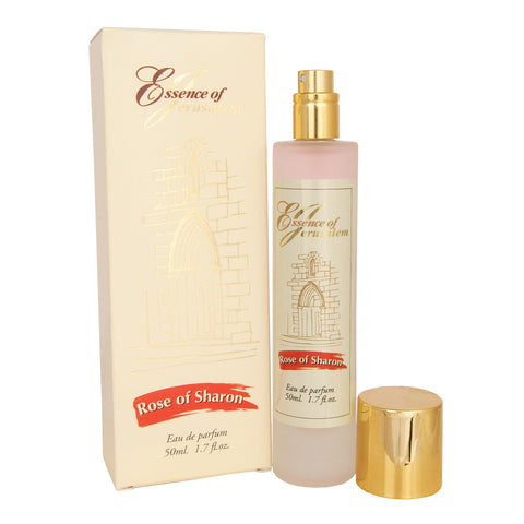 Close-up of a woman applying Rose of Sharon eau de parfum on her wrist, a serene expression on her face.