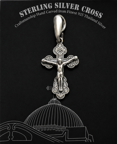 Silver crucifix pendant with raised Jesus figure on black display card, white Sterling Silver Cross text, polished bail, ornate cross details, and line drawing background
