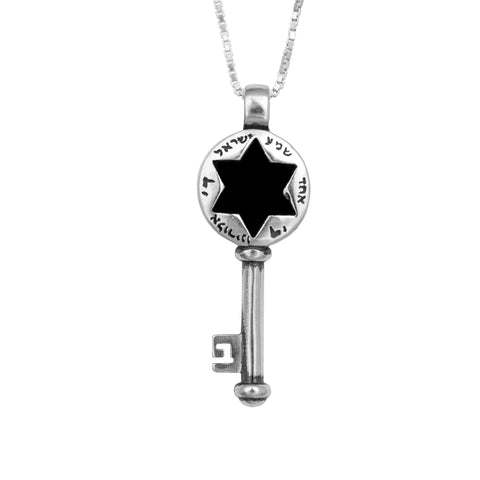 Silver-tone key pendant necklace with black six-point star cutout, Hebrew-style lettering around a round top, polished metal texture, front-facing view on white background.