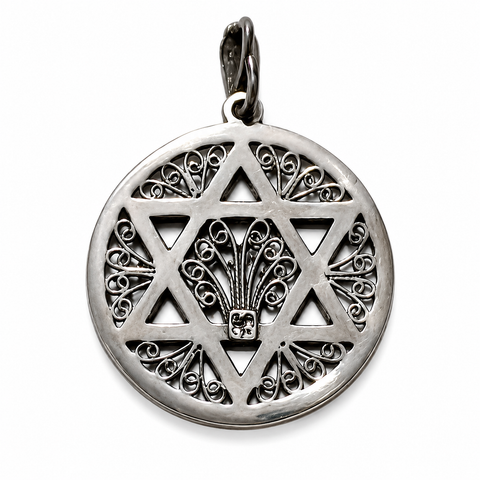 Reverse view of a round silver-tone pendant with an openwork Star of David, ornate scroll filigree, central fan-shaped motif, polished edges, dark recessed details, and a bail on a white background.