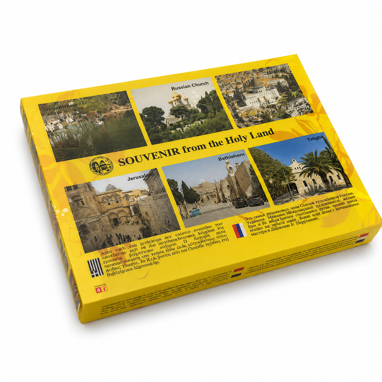 Back side of yellow Holy Land souvenir gift set box showing printed landmark photos, multilingual text, small flag icons, and glossy packaging on a white background